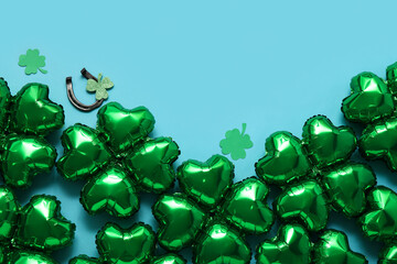 Balloons in shape of clover and horseshoe on blue background. St. Patrick's Day celebration