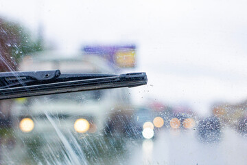Windshield wipers from inside of car, season rain. The problem of poor road visibility and traffic hazards on the road