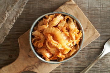 Fermented kim chi in a bowl on a wooden table, top view