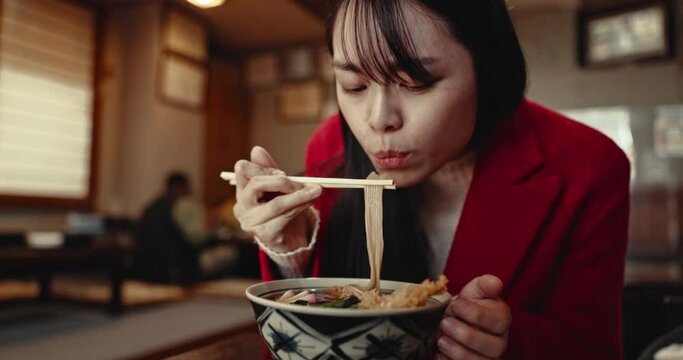 Woman, ramen and eating noodles in restaurant for nutrition, healthy meal and closeup with chopsticks. Person, Japanese cuisine and food for lunch or dinner in cafeteria with enjoyment and hungry