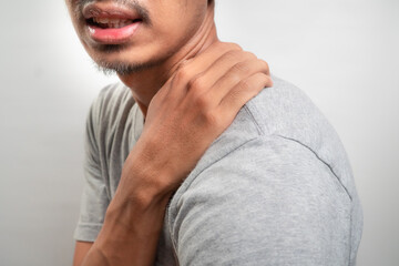 Fototapeta premium Man feels pain his shoulder isolated studio shot. isolated white background
