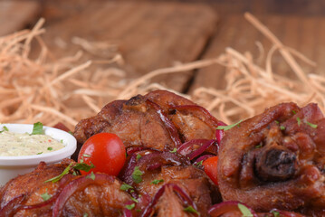 fried chicken dish with lemon tomatoes and fine herb sauce on wooden table