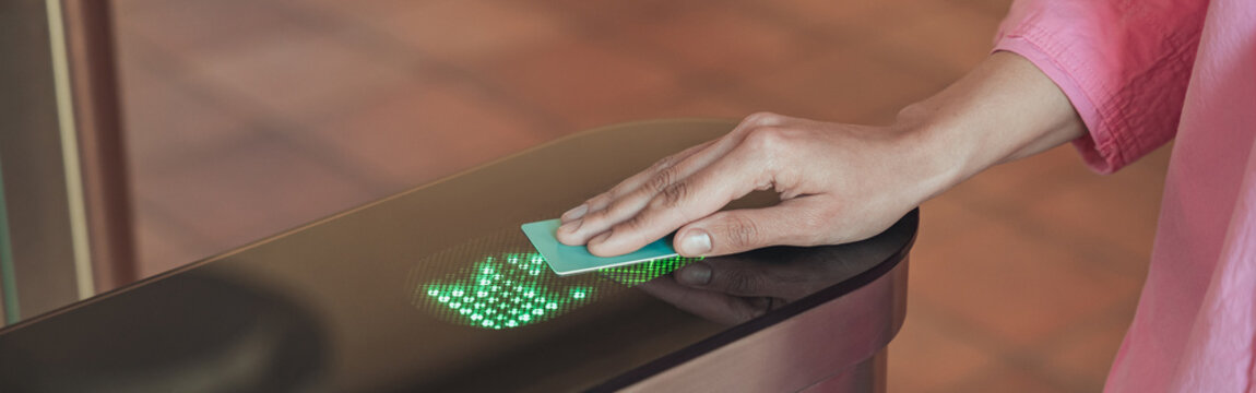 Close up of business woman passing through to office entrance gate after ID card authentication