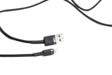 Black USB braided cable - Lightning isolated on a white background, close -up. (selective focus)