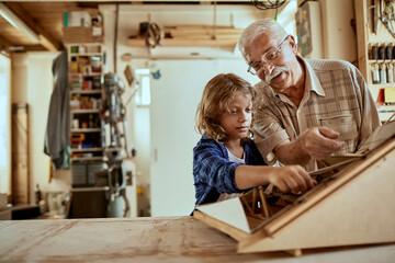 Grandfather and grandson working on a arts and crafts project in the garage