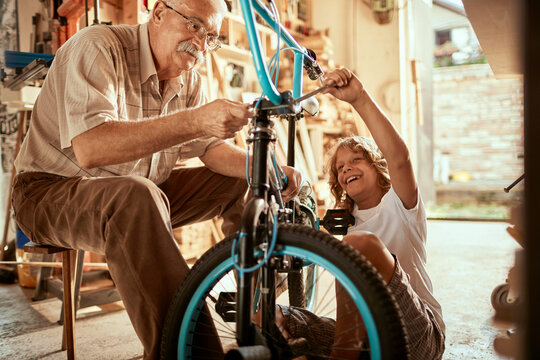 Grandfather and grandson working on a bicycle in the garage