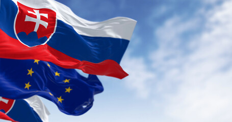 Close-up of Slovakia and the European Union flags waving on a clear day - obrazy, fototapety, plakaty