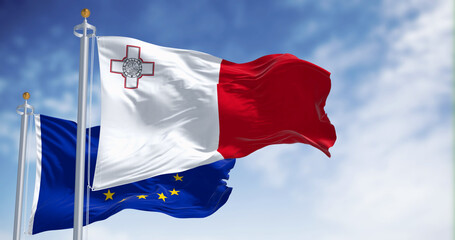 Flags of Malta and the European Union waving in the wind on a clear day