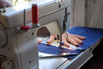 close-up of sewing machine with woman's hands horizontal
