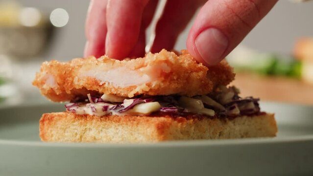 Chef cooking coleslaw and adding fried fish or chiken on top, german Coleslaw salad made of freshly shredded white cabbage and grated carrot with homemade mayonnaise. Famous thick cut sous vide beef