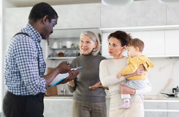 Adult male agent signing contract with family mother and daughter with child