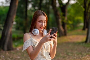 Young beautiful woman with headphone enjoying music and personal moment in a nature park