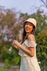 Beautiful young asian woman enjoying nature and sunset breeze at a park