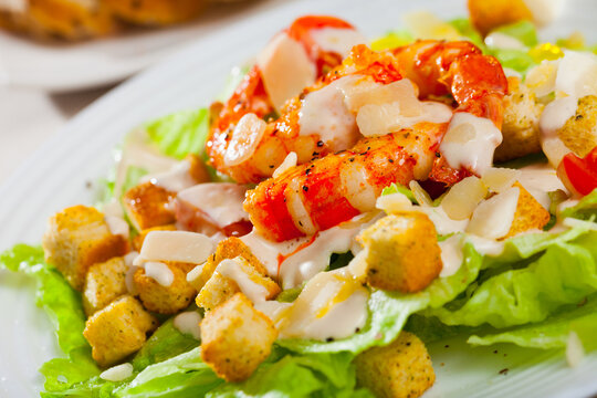 Image of fresh Caesar salad with shrimps on plate at restaurant