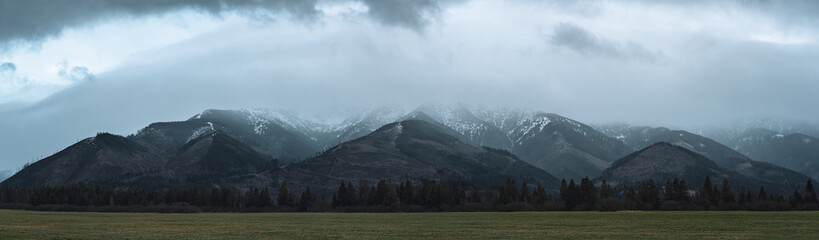 Panoramic winter mountain landscape of Low Tatras in Slovakia, scenic field and foggy mountains on horizon