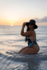 Mujer latina en el Mar Caribe con sombrero y lentes de sol