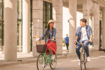 Fototapeta premium Couple riding on bicycles and having fun - Tourists driving around the city - Two friends riding bikes in downtown Guatemala.