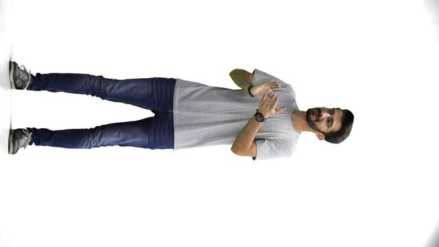 A man, on a white background, in full height, claps