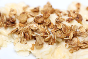 crushed banana with granola. details of crushed fruit with granola. breakfast details.
