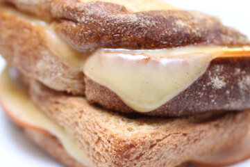 details of the sandwich with melted cheese. meal details texture of bread with melted cheese. sandwich with selective focus.