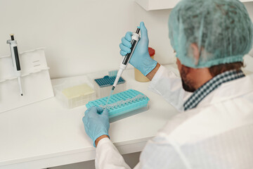 Back view of scientist is using micropipette for biochemical test analysis in medical laboratory