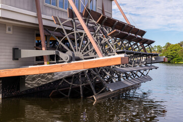 The rear of a large antique river boat.The paddle wheel has steel frame and blades with wooden...