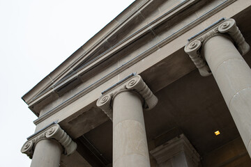 The exterior of a large courthouse with columns and pillars at the colonnade of the facade of the...