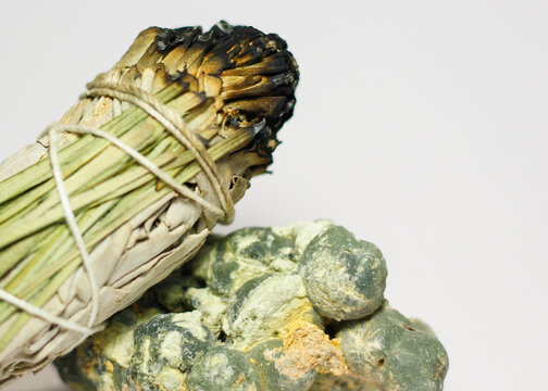 California White Sage and Sweetgrass Ceremonial Herb Bundle Resting on Rough Natural Formation of Green Prehnite Crystal Gemstone Mineral Healing Energy Crystal Cleansing Spiritual 