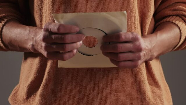 Retro Vinyl records in man hands close-up macro. Old disck for music. Retro vintage music player at home
