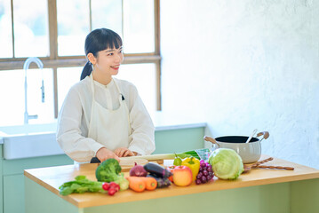 包丁で食材を切る若い女性