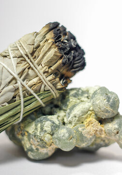 California White Sage and Sweetgrass Ceremonial Herb Bundle Resting on Rough Natural Formation of Green Prehnite Crystal Gemstone Mineral Healing Energy Crystal Cleansing Close Up