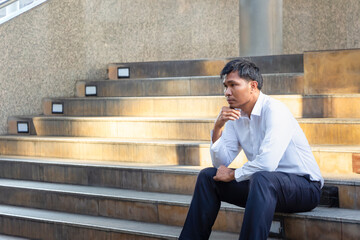 Lonely businessman lost in a depression on the stairs in the city, feeling sadness concepts