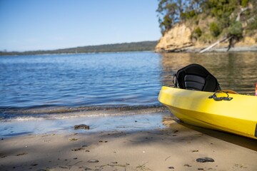 yellow canoe and kayak on a sandy beach in Australia in summer. kayaking on the sea in tasmania