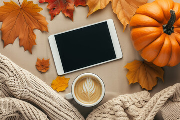 Autumn background with digital tablet mock up, coffee cup, warm sweater, fall leaves and pumpkin. Top view, flat lay.
