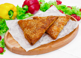 Samsa, bun, pastry on a wooden board