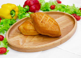 Pie with filling, bun, pastry on wooden board