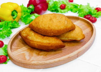 Fried mince pie, bun, pastry on a wooden board
