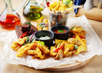 Assorted beer snack, shrimp, bread croutons, breaded fish, sauces, cheese, French fries