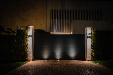 Sotogrande, Spain - January, 23, 2024 - A night view of a luxury home's entrance with a black...