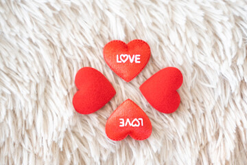 A cozy trio of red felt hearts on a soft, plush background, each heart a delicate token of love, perfect for romantic occasions and expressions of affection
