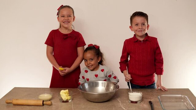 Niños felices hermanos con utensilios de cocina sobre mesa listos para preparar galletas dulces caseras para compartir con amor y cari&ntilde;o