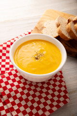 Homemade carrot and pumpkin cream soup. Easy, nutritious and healthy recipe. Served in a white bowl with bread croutons. Perfect to accompany everyday food.