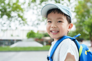 Asian Chinese boy in backpack and blue cap