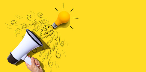 Attention and announcement concept with an idea light bulb flying to the sky like a rocket - Flat lay