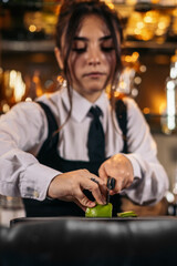 Bartender cutting limes to prepare cocktails