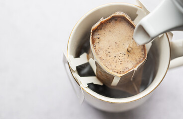 Drip coffee bag with ground coffee in  cup