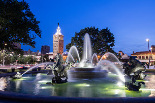 Twilight view of a historic fountain and skyline of Kansas City, Missouri, USA.
