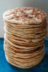 Flatbread lavash, chapati, naan, heap of tortilla on a blue background Homemade flatbread stacked.
