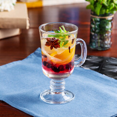 Mulled wine, drink with lemon, berries and mint on the table, cafe, lunch
