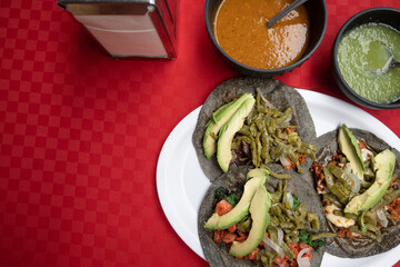 Authentic Mexican tacos accompanied with red and green sauce